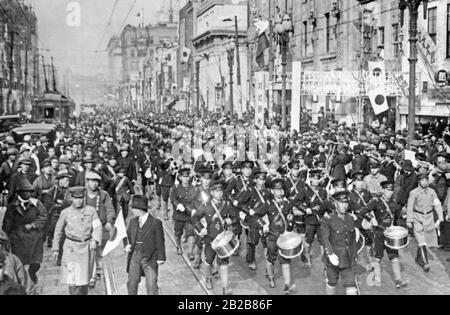 Un défilé militaire à Tokyo dans le cadre des célébrations de la Journée de l'armée japonaise le 10 mars 1932, accompagné de spectateurs de la ville. Banque D'Images