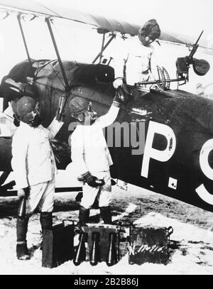 Un avion de chasse japonais est chargé de bombes par trois soldats. Ces derniers sont ensuite jetés à la main à l'extérieur de l'avion pendant le vol. Banque D'Images