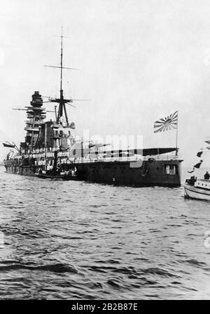 Le Navire De Guerre Japonais Mutsu. L'équipage est sur la terrasse. Le drapeau de la Marine impériale japonaise vole à l'arc du navire. Banque D'Images