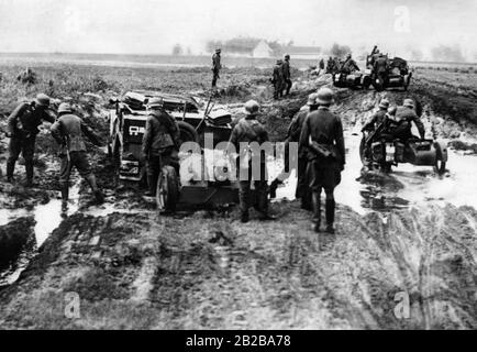 Motos et voiture avec un fusil d'infanterie dans la boue sur une route polonaise pendant l'avance de la campagne polonaise. Banque D'Images