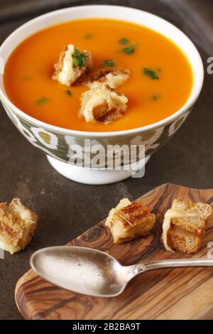 Soupe de punpkin épaisse dans un bol avec de petites morsures de croûtons de fromage grillé. Banque D'Images