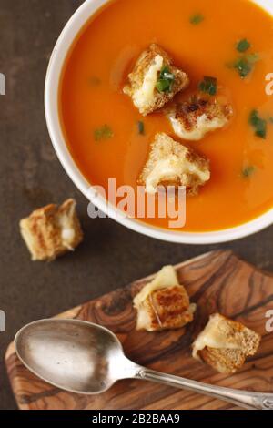 Soupe de punpkin épaisse dans un bol avec de petites morsures de croûtons de fromage grillé. Banque D'Images