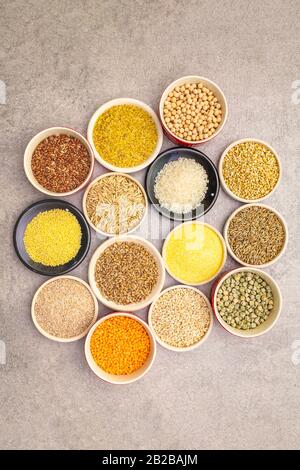 Concept de nourriture saine végétarienne (végétalien). Assortiment de céréales biologiques, légumineuses, grains entiers. Dans des bols en céramique sur un fond de pierre, gros plan, à Banque D'Images