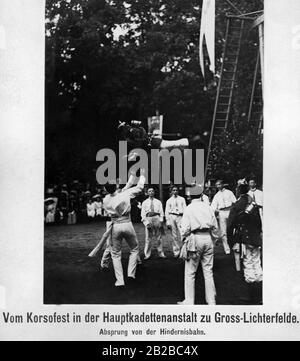 Lors d'un défilé de la Hauptkadettenanstalt (école supérieure de cadets) dans Gross-Lichterfelde un cadet en uniforme saute du parcours de l'obstacle et est pris par ses camarades avec ses mains. Banque D'Images