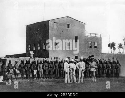 Une entreprise soudanaise devant la station allemande Bagamoyo en Afrique de l'est allemande. Après que l'officier allemand Hermann von Wissmann ait écrasé la révolte arabe en Afrique de l'est, il est resté commandant de la Schutztruppe. Banque D'Images