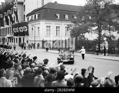 Le député d'Adolf Hitler, Rudolf Hess, quitte la Chancellerie du Reich pour se rendre aux Jeux olympiques du Reichsssportfeld à Berlin. Les foules lui montrent le salut nazi lorsqu'il quitte la Chancellerie du Reich dans sa voiture. Banque D'Images