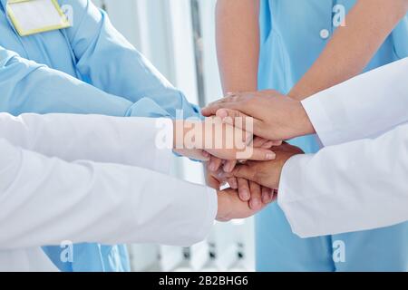 Image rapprochée des médecins et des infirmières qui empilent les mains et expriment leur soutien Banque D'Images