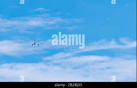 Compagnie aérienne commerciale volant sur ciel bleu et nuages blancs moelleux. Avion volant le jour ensoleillé. Vue arrière de l'avion international de passagers. Été Banque D'Images