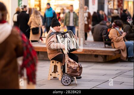 Vienne, Autriche - 02/29/2020: Musicien de rue jouant à l'accordéon à Vienne Kaernter Strasse par temps froid en hiver Banque D'Images