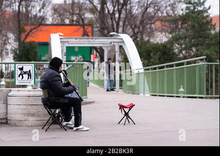 Vienne, Autriche - 02/29/2020: Musicien de rue jouant à la clarinette à Vienne Stadtpark une journée froide en hiver Banque D'Images