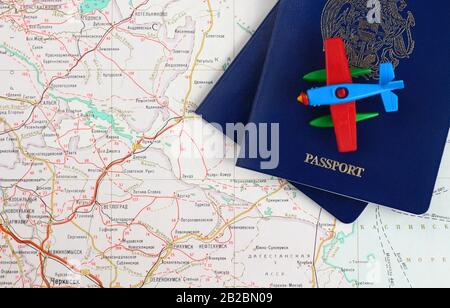 Concept de voyage. Morceaux de deux passeports bleus et un avion jouet sur une carte. Vue de dessus. Banque D'Images