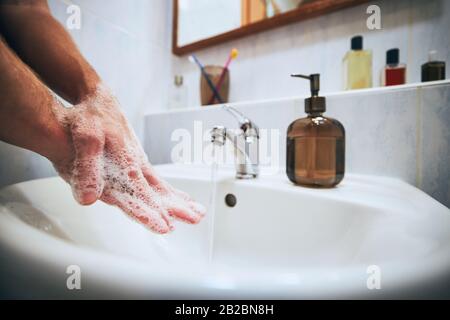 Se laver les mains à la maison dans la salle de bains. Un mode de vie sain, une hygiène et une prévention des maladies virales et bactériennes. Banque D'Images