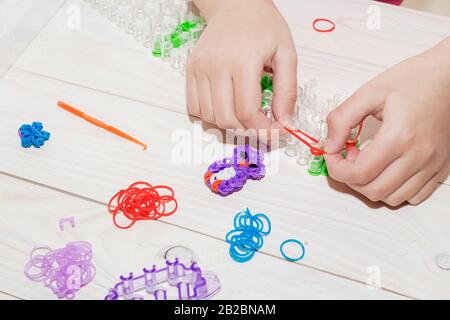 Main de fille avec bracelets et anneaux en caoutchouc Banque D'Images