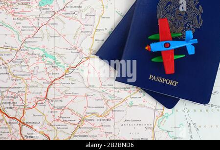 Concept de voyage. Morceaux de deux passeports bleus et un avion jouet sur une carte. Vue de dessus. Banque D'Images