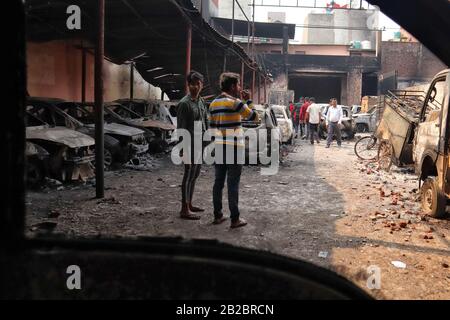 29 février 2020: Les gens marchent en dehors des voitures brûlées après qu'une place de stationnement a été incendiée par une foule lors des émeutes dans la région de Chandbagh à New Delhi, en Inde, le 29 février 2020. Plus de 40 personnes ont été tuées et des centaines de personnes blessées dans des émeutes qui ont éclaté le 24 février au sujet de la loi controversée sur la citoyenneté dans le nord-est de Delhi. Crédit: Muzamil Mattoo/Imageslive/Zuma Wire/Alay Live News Banque D'Images