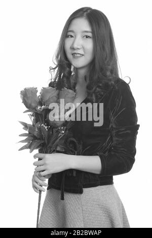 Jeune femme asiatique heureuse tenant des roses rouges prêt pour la Saint-Valentin Banque D'Images