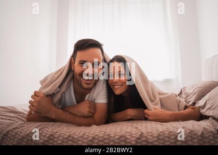 Heureux couple s'amuse au lit. Banque D'Images