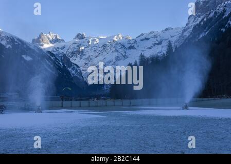 Machine à neige déversant de la neige artificielle sur une piste de ski à Engelberg sur les alpes suisses Banque D'Images