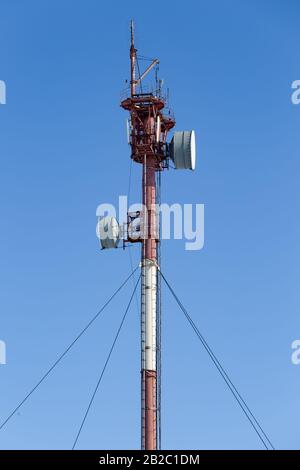 Mât avec antennes de relais radio contre un ciel bleu Banque D'Images