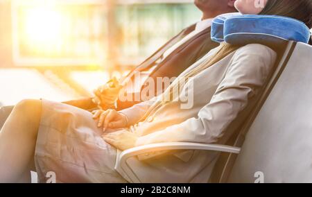 Homme d'affaires mûr et jeune femme d'affaires séduisante dormant en attendant d'embarquer dans leur porte à l'aéroport Banque D'Images