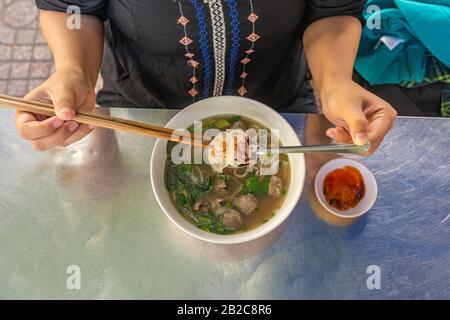 Vue de dessus de la femme locale qui mange de la soupe aux nouilles Pho Banque D'Images