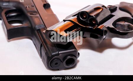 Deux pistolets, un pistolet noir de calibre 40 et un revolver à nez à priser noir 38 sur fond blanc Banque D'Images
