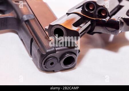 Deux pistolets, un pistolet noir de calibre 40 et un revolver à nez à priser noir 38 sur fond blanc Banque D'Images