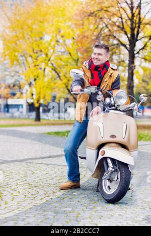 Portrait d'un homme mûr et séduisant assis sur un vélo tout en attendant dans le parc Banque D'Images