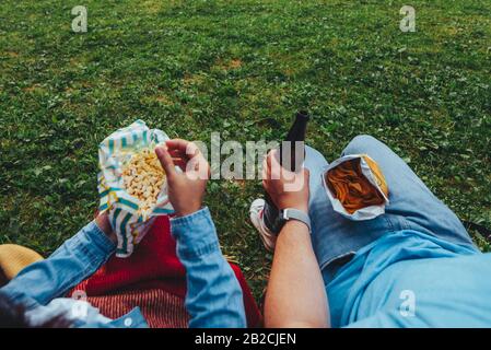 point de vue couple à l'extérieur manger du popcorn boire de la bière pas de visage Banque D'Images