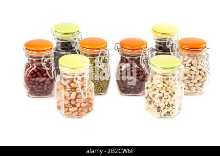 La collection de différents haricots dans les pots de verre isolés sur un fond blanc. Banque D'Images