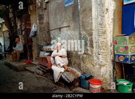 Photographie de voyage - l'homme égyptien lisant dans les ruelles du Caire islamique en Egypte en Afrique du Nord Moyen-Orient - Livre éducation Banque D'Images