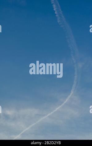 Suivi de l'avion dans le ciel. Courbe de condensation traînée dans le ciel bleu avec un léger brume. Le transport aérien et l'environnement. Arrière-plan naturel. S Banque D'Images