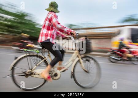 Motion photo floue d'une femme vietnamienne sur un vélo Banque D'Images