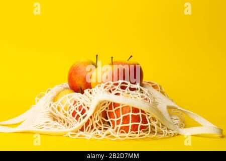Concept zéro déchet. Pommes dans un sac à cordes sur fond jaune. Pas de sacs en plastique dans les supermarchés et les magasins concept. Banque D'Images