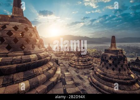 La vue étonnante de stupas en pierre ancienne au temple bouddhiste Borobudur contre beau paysage sur l'arrière-plan. Grande architecture religieuse. Magelang, C Banque D'Images