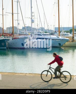 Homme à vélo au port de Barcelone Vell. Espagne. Flou de mouvement Banque D'Images