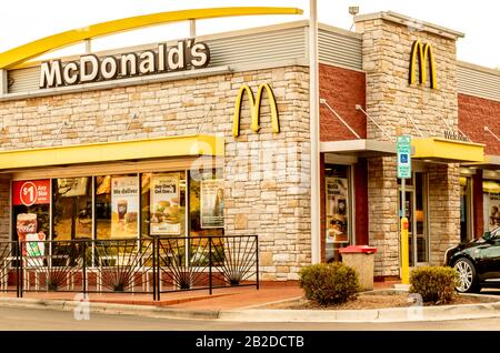 Charlotte, NC/USA - 12 octobre 2019: Façade extérieure en pierre beige de McDonald's montrant la marque/le logo en lettres blanches et noires, arches jaunes, fenêtres Banque D'Images