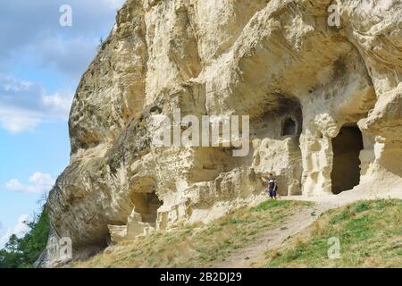 Un touriste se tient à la limite naturelle de Mariam-Dere près de Bakhchisarai. Grotte Chufut-Kale Banque D'Images