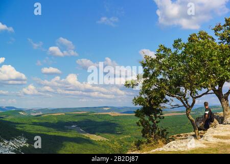 Tourisme en admirant la vue sur le paysage de la vallée ashlama-Dere sur le côté nord de la cité médiévale-forteresse Chufut-Kale. Arête intérieure de Crimean Banque D'Images