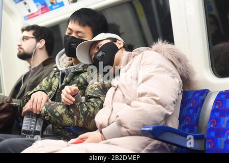 Un homme et une femme portant un masque facial lorsqu'ils voyagent sur un train de métro sur la ligne Jubilee du métro de Londres, comme l'a dit le secrétaire à la Santé fantôme, Jonathan Ashworth, il serait favorable à la fermeture de villes pour contrôler la propagation du coronavirus. Photo PA. Date de la photo: Lundi 2 mars 2020. S'exprimant lundi sur le petit-déjeuner de la BBC, M. Ashworth a dit qu'il souhaitait que le gouvernement clarifiait ses prochaines étapes pour contenir le virus Covid-19. Interrogé sur son soutien à la fermeture de villes pour empêcher la propagation au Royaume-Uni, M. Ashworth a déclaré : « si le conseil médical et le conseil scientifique doivent être pris Banque D'Images