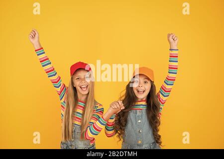 Gagnants d'atteindre leur but. Heureux les petits enfants faisant des gestes gagnant sur fond jaune. Gagnants petit mignon jouissant de bonheur. Heureux gagnants célébrant la victoire ou le succès ensemble. Banque D'Images