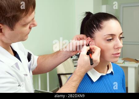 Le chirurgien plastique examine l'oreille du patient avant la chirurgie plastique et les lignes de dessin Banque D'Images