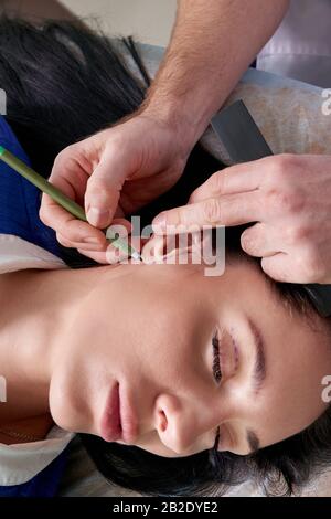 Le chirurgien plastique examine l'oreille du patient avant la chirurgie plastique Banque D'Images