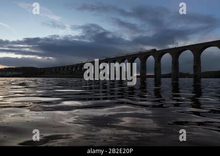 Un train Arriva Crosscountry de classe 220 traversant le pont de la frontière royale (Berwick-Upon-Tweed, rivière Tweed) sur la ligne principale de la côte est au crépuscule, au Royaume-Uni Banque D'Images