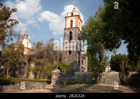 Vue sur les tours et les parties du dôme de l'ancien couvent de Culhuacán à Mexico se demande parmi la ville Banque D'Images