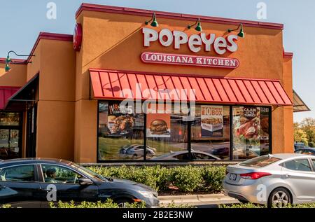 Charlotte, NC/USA - Novenber 9, 2019: Feu moyen extérieur de marque rouge et blanche 'Popeyes Louisiana Kitchen' sur la façade du bâtiment avec auvent Banque D'Images