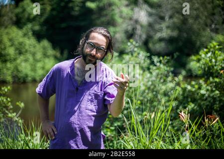 Un portrait d'un jeune homme barbu avec une drôle d'expression faciale. Un homme gai qui a l'air surpris et qui dit avec un geste de la main - venez ici ou quoi Banque D'Images