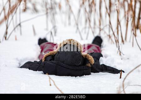 Une fille pratiquant le yoga à l'extérieur pendant une journée d'hiver typique. La fille se trouve dans la neige un jour d'hiver dans la forêt. Un exercice de yoga pendant une journée d'hiver Banque D'Images