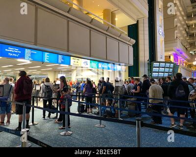 Orlando,FL/USA-2/27/20: Les gens qui attendent en ligne pour passer par l'aéroport international d'Orlando MCO sécurité TSA une journée chargée. Banque D'Images