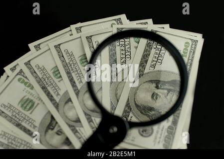 Contexte de beaucoup d'argent billets de 100 dollars américains canadiens dans une pile avec une loupe qui augmente les revenus Banque D'Images